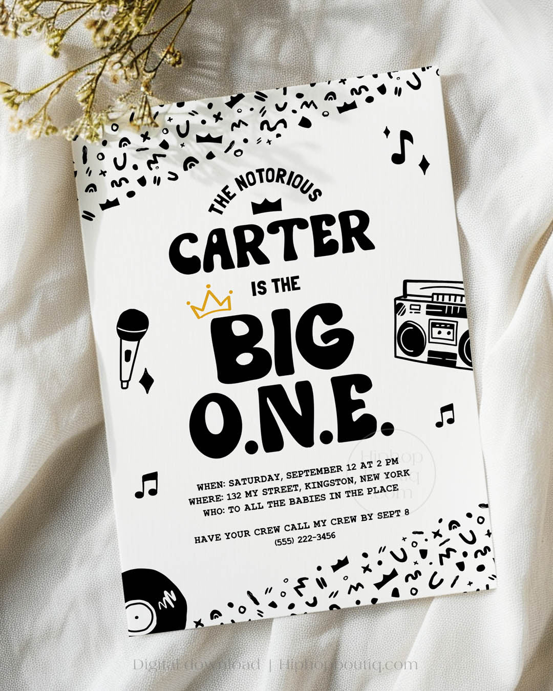 Hip-hop themed, printed birthday invitation card. The card features an editable 'The Big One' design including a customizable child's name. The card also features a black and white squiggly pattern, 90s rap-themed illustrations, and a golden crown.