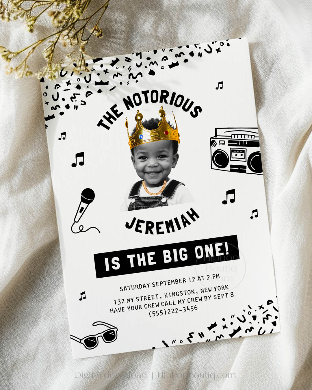 Hip-hop themed, printed birthday invitation card. The card features an editable 'Notorious One' design with a black and white squiggly pattern, and an image of a happy child wearing a crown and a gold chain.