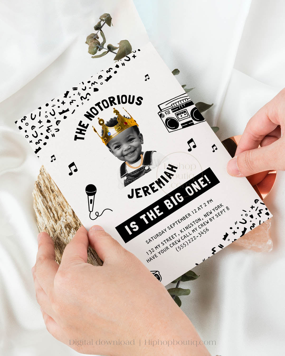 Hip-hop themed, printed birthday invitation card. The card features an editable 'Notorious One' design with a black and white squiggly pattern, and an image of a happy child wearing a crown and a gold chain. 